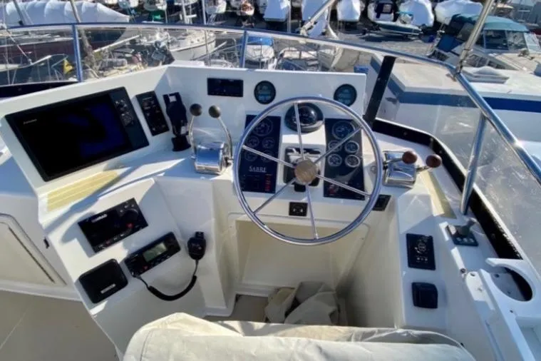 Slide: The Image of 2004 Sabre 42 Fly Bridge helm with steering wheel, gauges, and navigation equipment. - 3