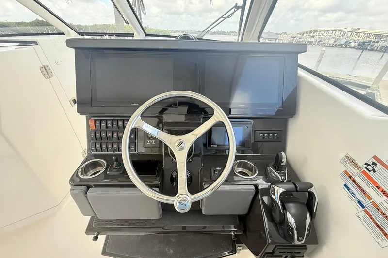 Slide: The Image of 2022 Pursuit DC 365 Dual Console helm with steering wheel and navigation screens. - 14