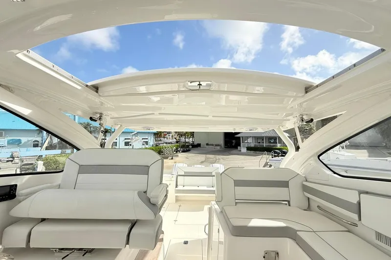 Slide: The Image of 2022 Pursuit DC 365 Dual Console boat interior with spacious seating and open roof. - 17