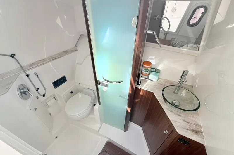 Slide: The Image of 2022 Pursuit DC 365 Dual Console boat bathroom with modern fixtures and glass sink. - 19