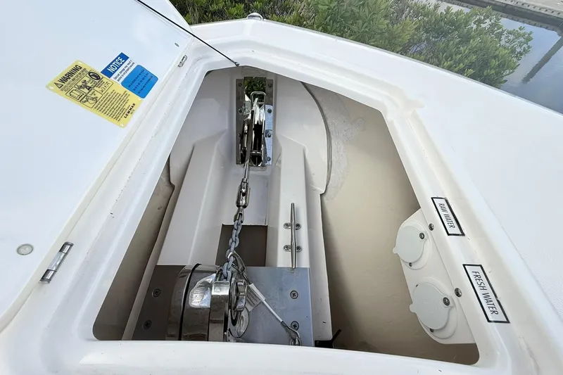 Slide: The Image of Anchor compartment of 2022 Pursuit DC 365 Dual Console boat with chain and water access. - 21