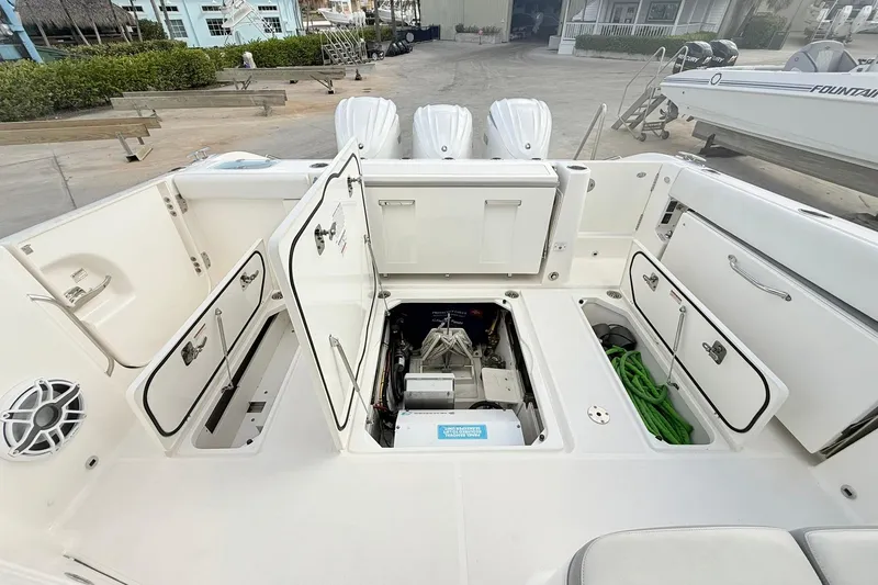 Slide: The Image of 2022 Pursuit DC 365 Dual Console boat with open storage compartments and visible engine. - 22