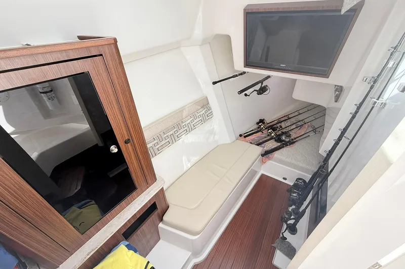 Slide: The Image of Interior of 2022 Pursuit DC 365 Dual Console with fishing rods and seating area. - 26