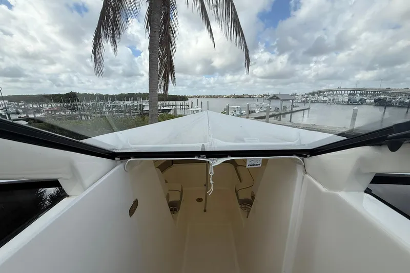 Slide: The Image of 2022 Pursuit DC 365 Dual Console boat docked with scenic marina view. - 28