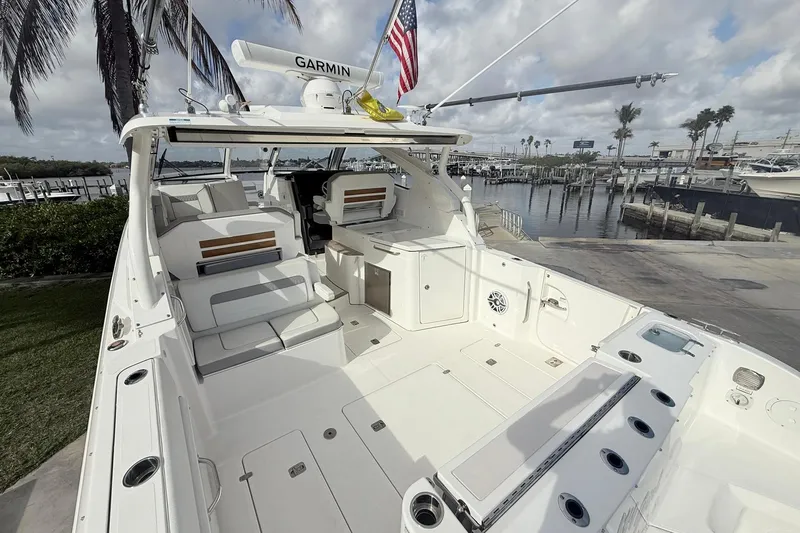 Slide: The Image of 2022 Pursuit DC 365 Dual Console boat docked, featuring spacious seating and modern amenities. - 6