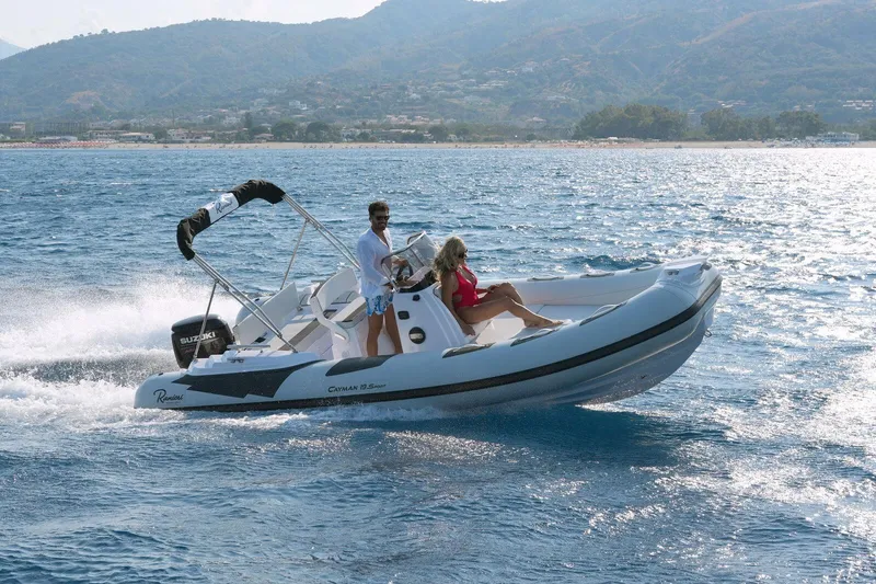 Slide: The Image of 2026 Ranieri CAYMAN 19 Sport boat cruising on open water with scenic mountain backdrop. - 3