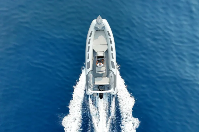 Slide: The Image of 2026 Ranieri Cayman 21.0 Sport boat cruising on open blue water. - 2