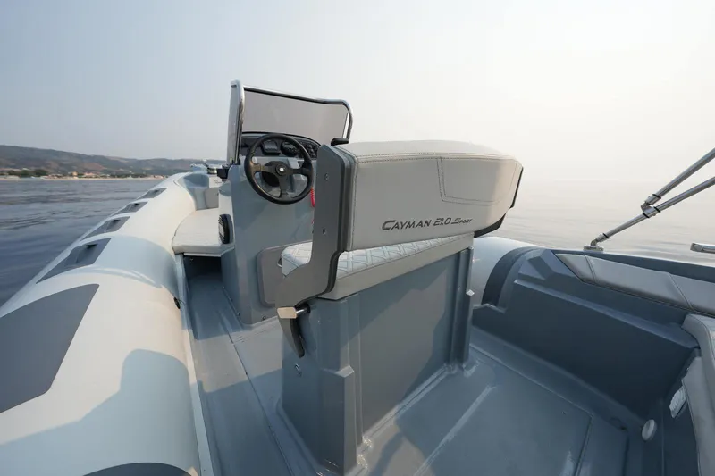 Slide: The Image of 2026 Ranieri Cayman 21.0 Sport boat interior with steering wheel and seating. - 8