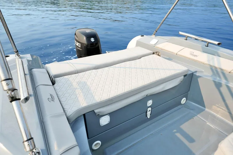 Slide: The Image of 2026 Ranieri Cayman 21.0 Sport boat interior with Suzuki outboard motor on calm water. - 9