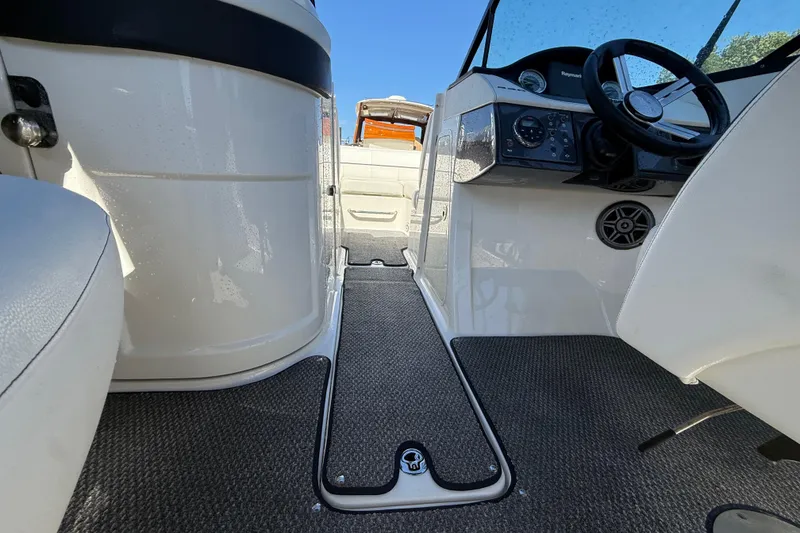 Slide: The Image of 2014 Sea Ray 220 Sundeck interior with steering wheel and seating area. - 10