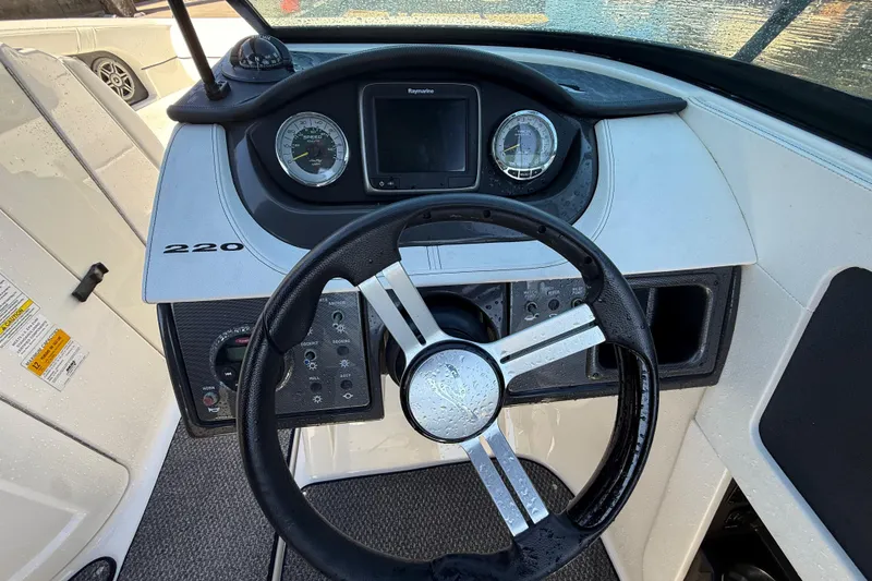 Slide: The Image of Steering console of a 2014 Sea Ray 220 Sundeck boat with gauges and controls. - 13