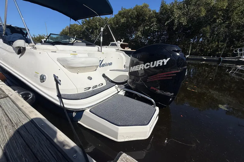 Slide: The Image of 2014 Sea Ray 220 Sundeck with Mercury outboard engine docked by wooden pier. - 3