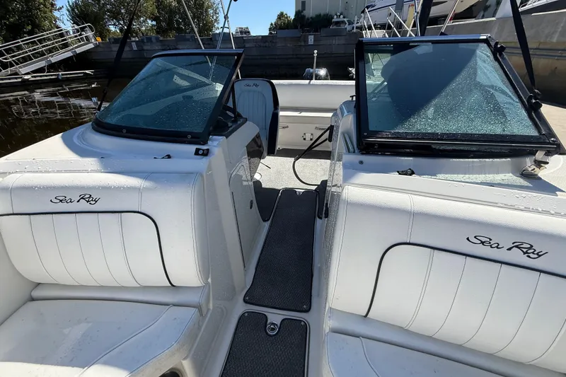 Slide: The Image of 2014 Sea Ray 220 Sundeck boat interior with white seating and windshield. - 4