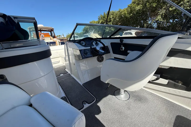 Slide: The Image of 2014 Sea Ray 220 Sundeck interior with steering wheel and seating. - 7