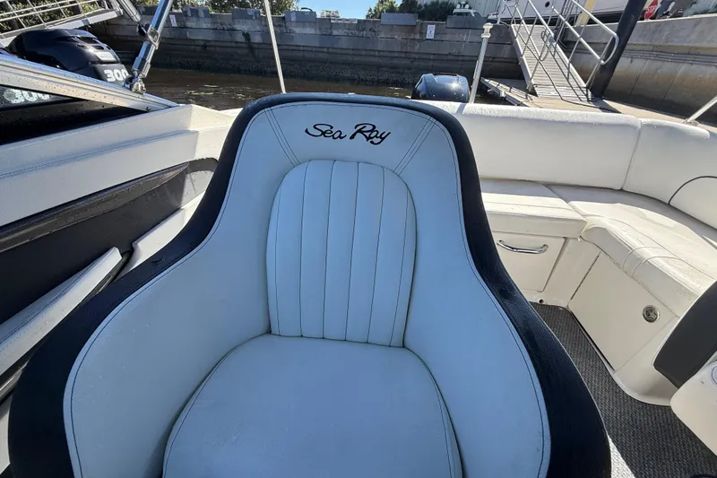 Slide: The Image of 2014 Sea Ray 220 Sundeck boat interior with white seating and logo. - 8