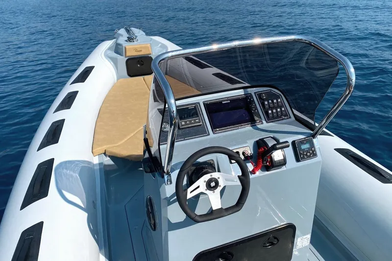 Slide: The Image of 2026 Ranieri Cayman 26.0 Sport boat with modern dashboard on calm blue water. - 7
