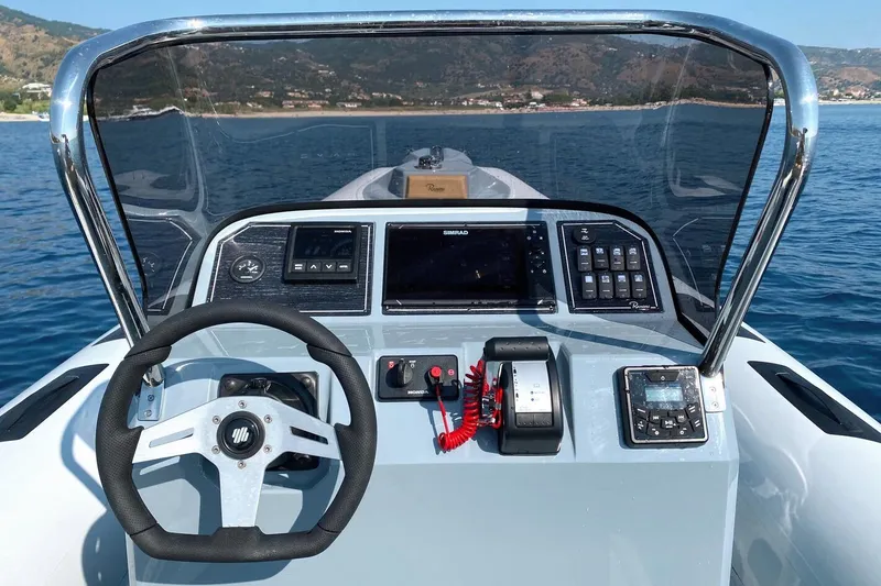 Slide: The Image of Steering console of 2026 Ranieri Cayman 26.0 Sport boat on open water. - 8
