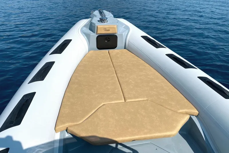 Slide: The Image of 2026 Ranieri Cayman 26.0 Sport boat with beige sunbed on calm blue water. - 9