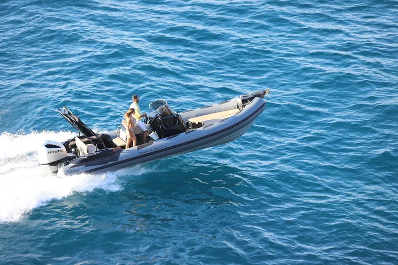 Slide: The Image of 2026 Ranieri Cayman 26.0 Sport Touring boat cruising on clear blue water. - 2