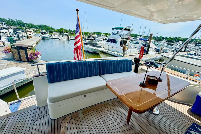 Slide: The Image of 2012 Grand Banks 53 Aleutian RP yacht at marina with seating and American flag. - 16