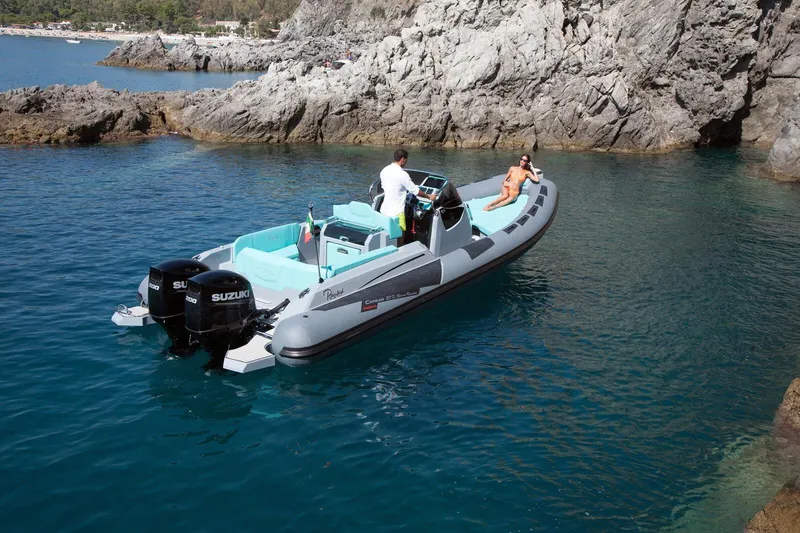 Slide: The Image of 2026 Ranieri CAYMAN 27.0 SPORT TOURING boat cruising in clear blue waters near rocky cliffs. - 5