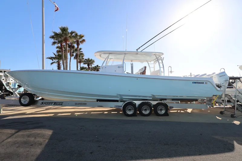 The Image of 2026 Contender 44 CB boat on trailer under bright sunlight at marina. - 0