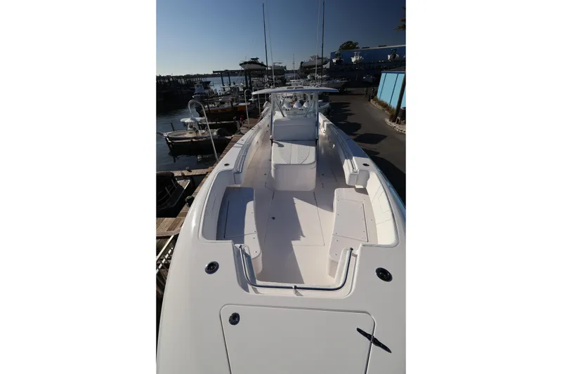 Slide: The Image of 2026 Contender 44 CB boat docked at marina, featuring sleek white seating and modern design. - 27