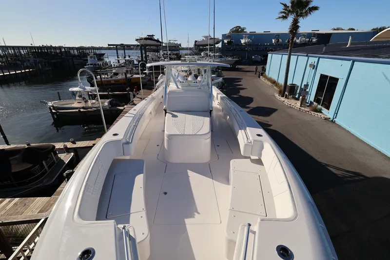 Slide: The Image of 2026 Contender 44 CB boat with luxurious white seating at a marina. - 28