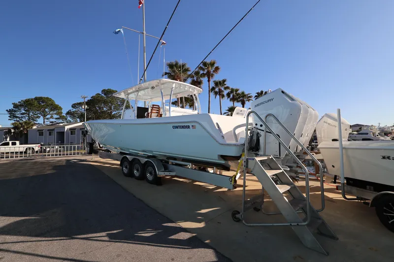 Slide: The Image of 2026 Contender 44 CB boat on trailer, parked near palm trees under clear sky. - 3