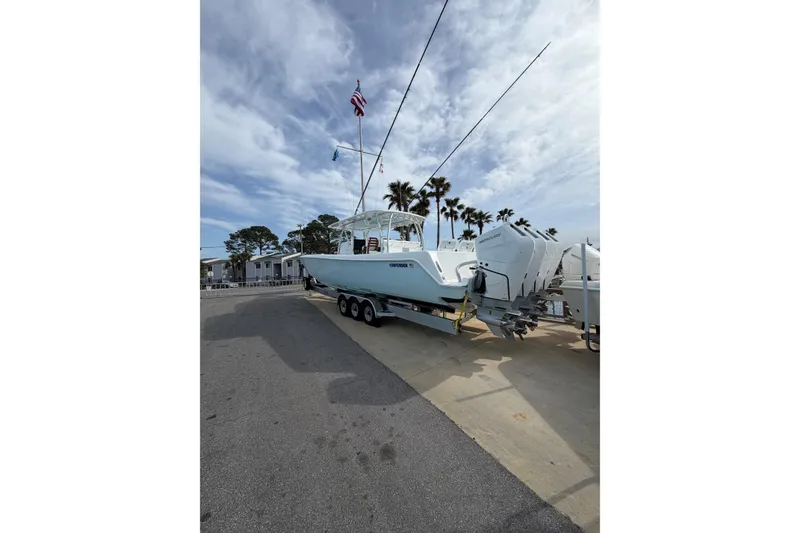 Slide: The Image of 2026 Contender 44 CB boat on trailer with triple Mercury engines, parked outdoors. - 4