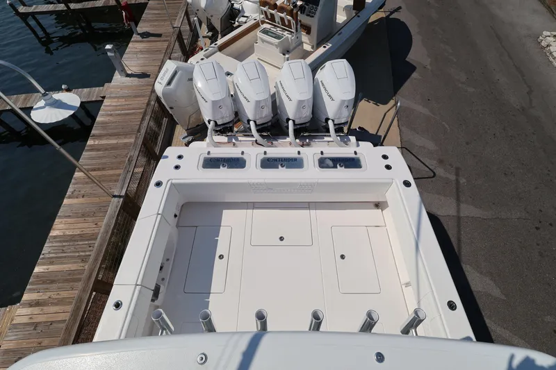 Slide: The Image of 2026 Contender 44 CB boat with four outboard engines docked at a marina. - 43