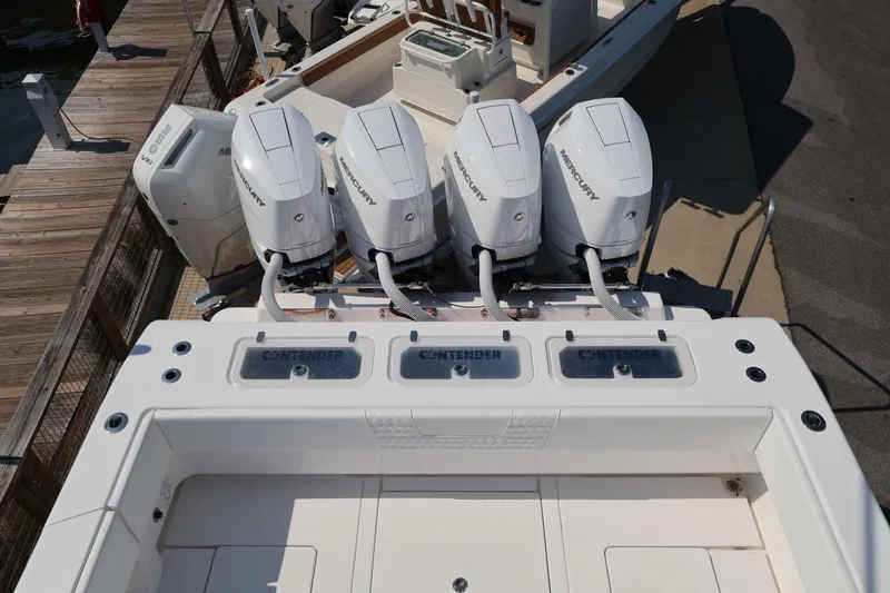 Slide: The Image of 2026 Contender 44 CB boat with four Mercury outboard engines at dock. - 44