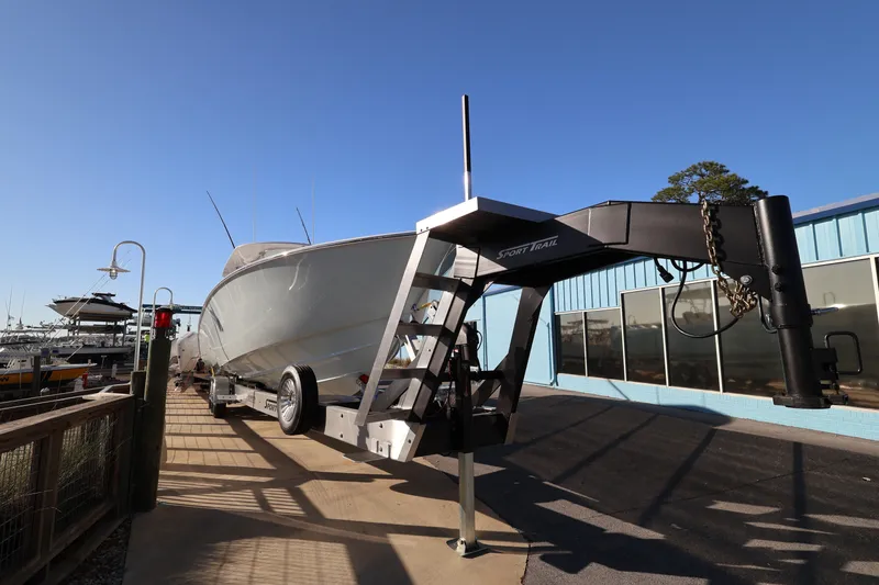 Slide: The Image of 2026 Contender 44 CB boat on trailer with outboard motors, parked near palm trees. - 5