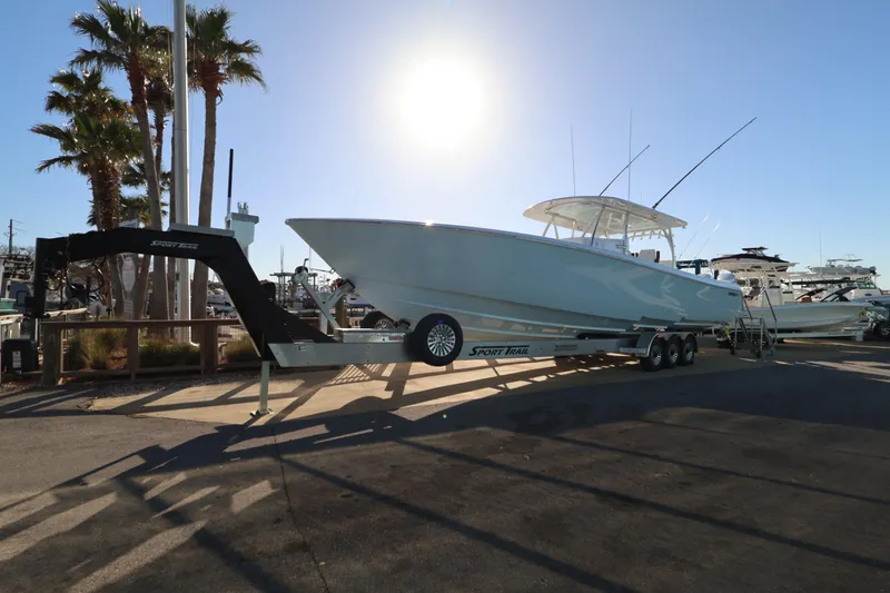 Slide: The Image of 2026 Contender 44 CB boat on trailer at marina under clear blue sky. - 6