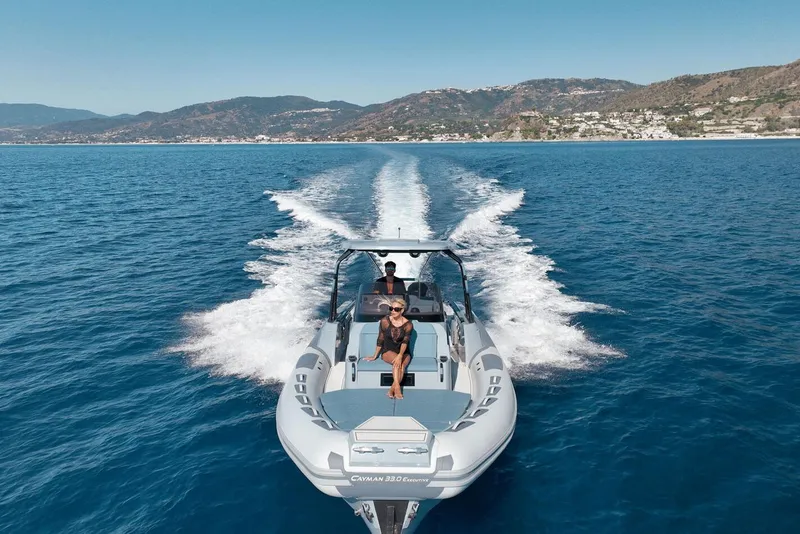 Slide: The Image of 2026 Ranieri CAYMAN 33.0 EXECUTIVE cruising on open sea with scenic coastline. - 2