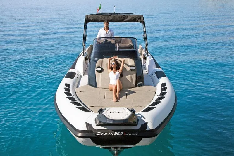 Slide: The Image of 2026 Ranieri CAYMAN 35.0 EXECUTIVE boat on clear blue water, with two people relaxing onboard. - 9