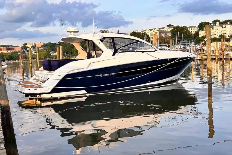 The Image of 2015 Cruisers Yachts 390 Express Coupe docked in a scenic marina setting. - 0