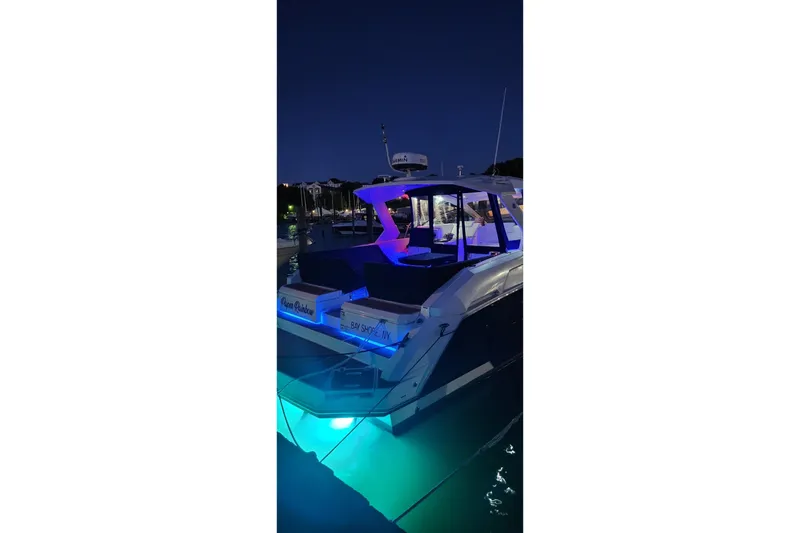 Slide: The Image of 2015 Cruisers Yachts 390 Express Coupe illuminated at night in a marina. - 17