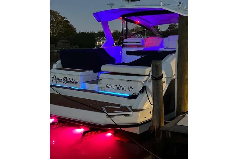 Slide: The Image of 2015 Cruisers Yachts 390 Express Coupe docked with vibrant underwater lights. - 2