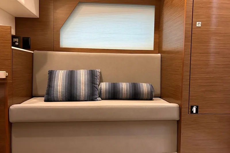 Slide: The Image of Interior of 2015 Cruisers Yachts 390 Express Coupe with cushioned seating and striped pillows. - 24