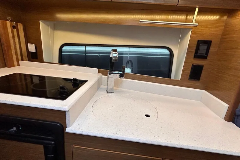 Slide: The Image of 2015 Cruisers Yachts 390 Express Coupe kitchen with modern sink and stovetop. - 27