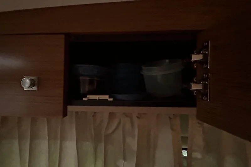 Slide: The Image of Open wooden cabinet with containers inside on a 2015 Cruisers Yachts 390 Express Coupe. - 37