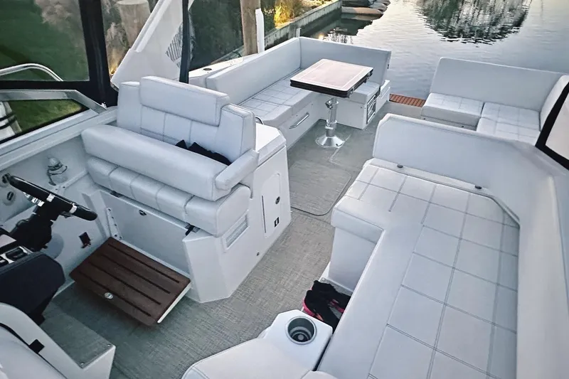 Slide: The Image of 2015 Cruisers Yachts 390 Express Coupe interior with plush seating and table by the water. - 5