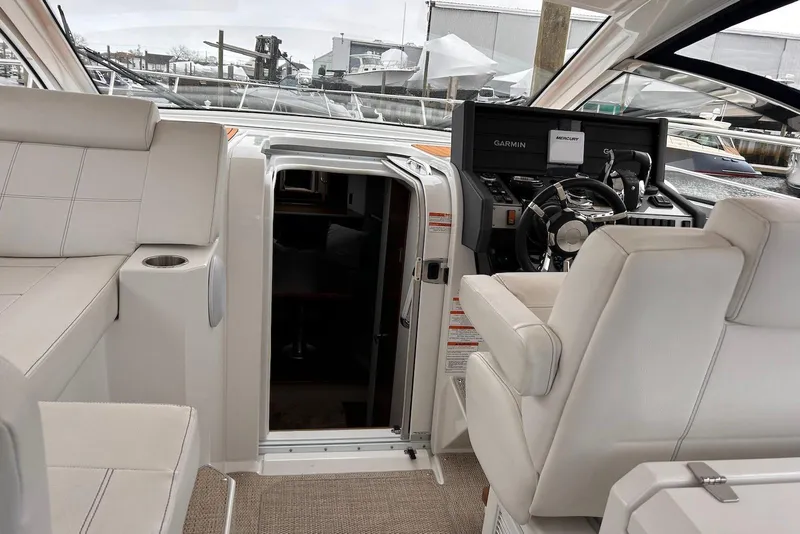 Slide: The Image of 2015 Cruisers Yachts 390 Express Coupe interior with helm and seating area. - 8
