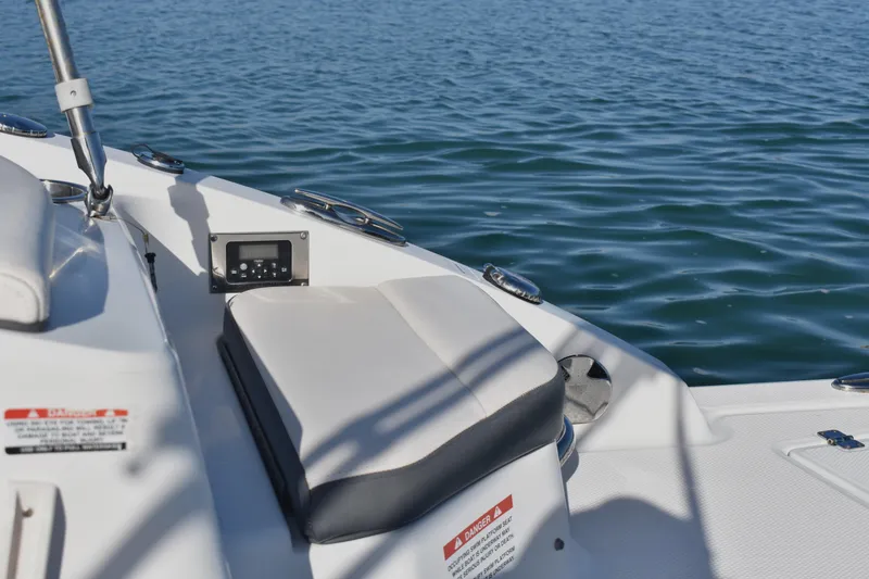 Slide: The Image of 2017 Chaparral 230 Suncoast boat interior with seating and control panel on water. - 15