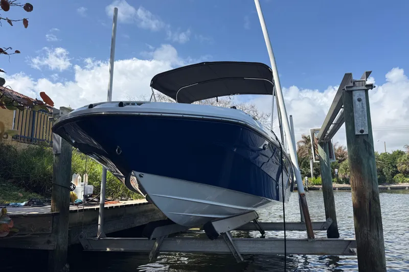 Slide: The Image of 2023 Hurricane SunDeck Sport 205 OB boat on lift by the water. - 10