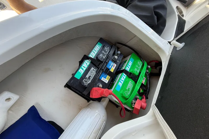 Slide: The Image of Battery compartment of 2023 Hurricane SunDeck Sport 205 OB boat, featuring Interstate batteries. - 16