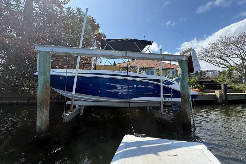 Slide: The Image of 2023 Hurricane SunDeck Sport 205 OB boat on lift by waterfront home. - 5