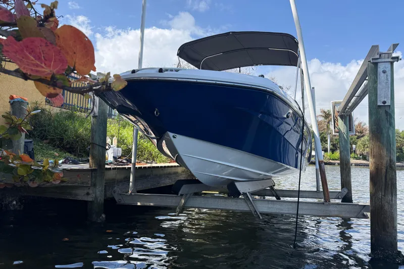 Slide: The Image of 2023 Hurricane SunDeck Sport 205 OB boat on lift by waterfront. - 9