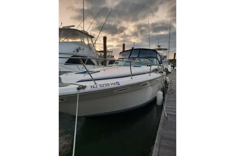 Slide: The Image of 1990 Sea Ray Sundancer 370 docked at sunset with cloudy sky backdrop. - 2